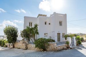 a white house with a stone wall at Aeolos Villa Cleo in Agkidia