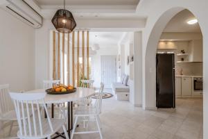 a kitchen and dining room with a table and chairs at Aeolos Villa Cleo in Agkidia
