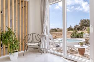 a balcony with a chair and a swimming pool at Aeolos Villa Cleo in Agkidia