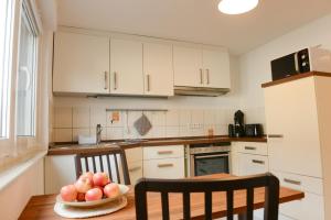a kitchen with a table with a bowl of fruit on it at Ferienwohnung Malou in Tettnang