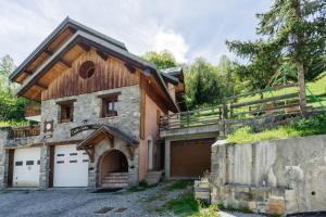 a house with two garage doors and a fence at Gentiane in Valloire