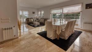 a dining room with a table and a living room at Costacabana - Villa Madison in Lloret de Mar