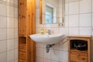 a bathroom with a sink and a mirror at Haus Janni in Freest +21 photos