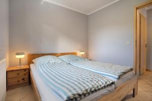 a bed with a blue and white striped comforter in a bedroom at Haus Janni in Freest