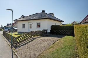 a white house with a fence in front of it at Haus Janni in Freest