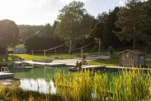 a house on a dock on a lake with a playground at Ferienwohnungen Uhren Allgaier in Schönwald