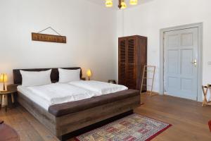 a bedroom with a large bed with white sheets at Kurfürstensuite in Brandenburg an der Havel +15 photos