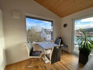 a dining room with a table and chairs and a large window at Ruhige Ferienwohnung im Hegau in Volkertshausen