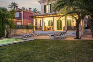 a house with a pool and palm trees at Villa Playa Felostal in Palma de Mallorca