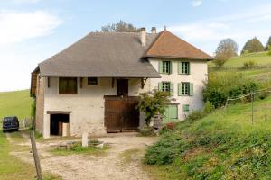 a large white house with a gate in a field at Le Palefroi De Merlas in Merlas