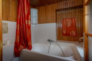 a bathroom with a tub with a red shower curtain at Le Palefroi De Merlas in Merlas +21 photos