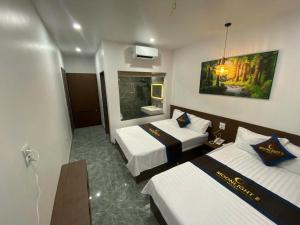 a hotel room with two beds and a mirror at Moonknight 2Hotel in Sầm Sơn