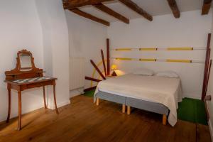 a bedroom with a bed and a mirror and a table at Le Palefroi De Merlas in Merlas