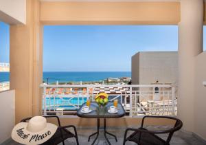 a balcony with a table and chairs and a view of the ocean at Sunrise Apartments Crete in Sfakaki