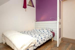 a bedroom with a bed with a purple wall at Chez Pierre et Germaine in Saint-Maurice-de-Rotherens