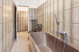 a bathroom with a tub and a tiled wall at Ferienwohnung am Fährhafen in Neu Darchau +21 photos