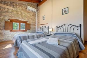 two beds in a room with a brick wall at Mas de Sisco in Flix +31 photos