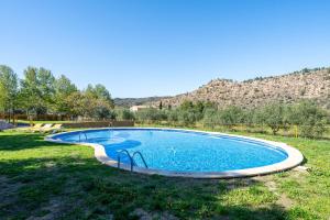 a swimming pool in a yard with mountains in the background at Mas de Sisco in Flix