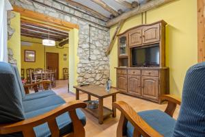 a living room with a television and a table at Mas de Sisco in Flix