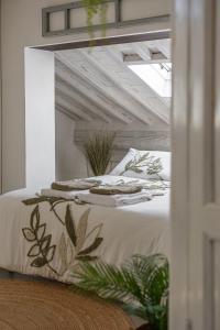 a bedroom with a bed with white sheets and plants at Il Nido in Buonconvento