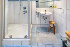 a bathroom with a shower and a sink and a tub at Ferienwohnung Waldeckchen in Waldeck +14 photos