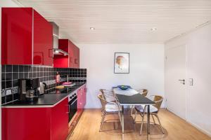a kitchen with red cabinets and a table with chairs at Ferienwohnung Waldeckchen in Waldeck