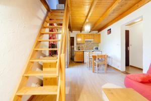 a wooden staircase in a room with a kitchen at Appartement n°8 - 5 personnes in Saint-Sorlin-dʼArves +20 photos