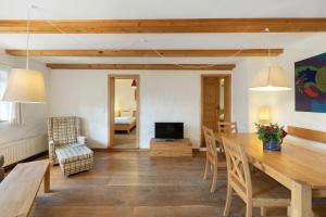 a living room with a dining room table and a bedroom at Zweilindenhof in Seeshaupt