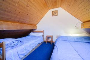 two beds in a room with a wooden ceiling at Appartement n°8 - 5 personnes in Saint-Sorlin-dʼArves