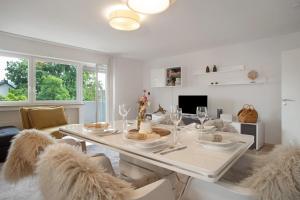a white dining room with a table and chairs at Geräumige schöne Ferienwohnung in Weingarten