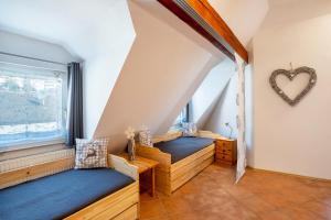 a attic room with two beds and a window at Schwarzwaldnest in Bad Wildbad