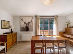 a dining room with a table and a deer on the wall at Chalet Lilette in Font-Romeu-Odeillo-Via