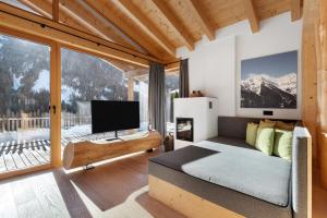 a bedroom with a bed and a tv and a window at Chalet Berg in Selva dei Molini
