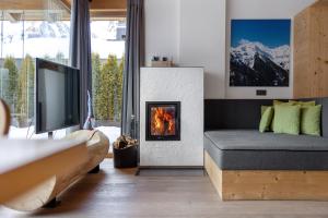 a living room with a couch and a fireplace at Chalet Berg in Selva dei Molini
