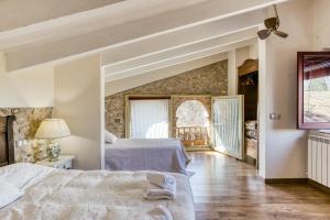 a bedroom with two beds and a window at Ca La Maria in Orriols