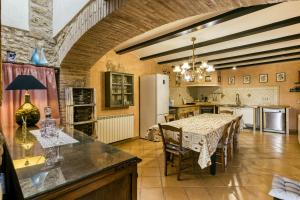 a kitchen with a table with chairs and a refrigerator at Ca La Maria in Orriols