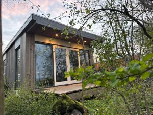 a tiny house in the woods with a large window at Litehomeatseagoedereede in Goedereede