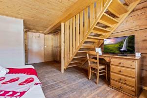 a bedroom with a bed and a desk with a television at L'Auberge de L'Ours in Vers L'Eglise