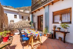 a patio with a table and chairs and a house at La lechuga azul in Güéjar-Sierra
