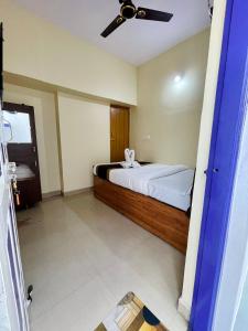 a bedroom with a bed with a ceiling fan at Casablis homestay in Mysore