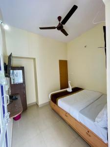 a bedroom with a bed and a ceiling fan at Casablis homestay in Mysore
