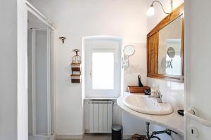 a white bathroom with a sink and a window at Uliveto in Lerici