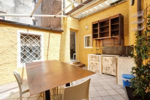 an outdoor kitchen with a wooden table and chairs at Uliveto in Lerici +20 photos