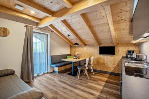 a kitchen with a table in a room with wooden ceilings at Krämerhof Apt Villnösser Geisler in Rodengo