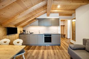 a kitchen and living room with a wooden ceiling at Krämerhof Apt Villnösser Geisler in Rodengo