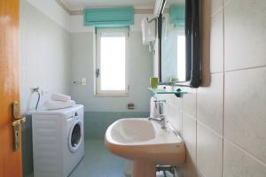 a bathroom with a sink and a washing machine at Elegante "casa Karm" 6 posti in Otranto +36 photos