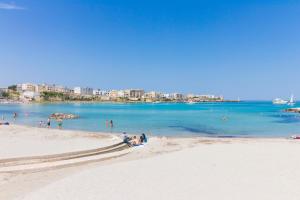 a group of people sitting on a beach at Elegante "casa Karm" 6 posti in Otranto