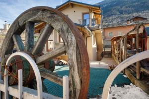 a wooden water wheel in front of a house at Antirouille Casa Vacanze in Aymavilles