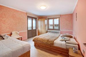 a bedroom with two beds and a chair in it at Lovin Winter in Livigno