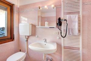 a pink bathroom with a sink and a toilet at Lovin Winter in Livigno +19 photos